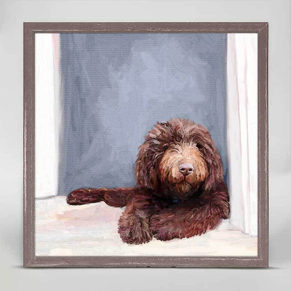 A colored print of a brown dog with curly short hair lying still against a wall.