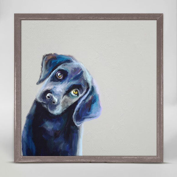 A colored print of a black puppy with yellowish-brown eyes and its head tilted.