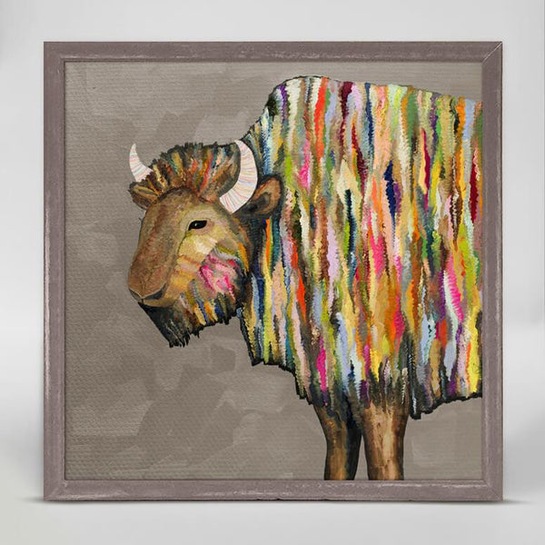 Painted in brightly colored stripes, a sideview of a  bison with head turned forward stands against a gray brown background.