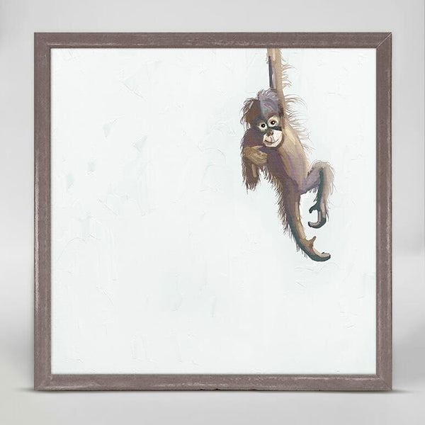A print in color of a young  baby monkey hanging by one arm.
